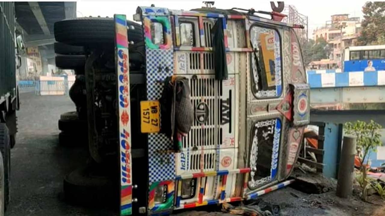 ভারের চোটে উল্টে গেল লরি, চরম ভোগান্তি বিমানবন্দরগামী রাস্তায়
