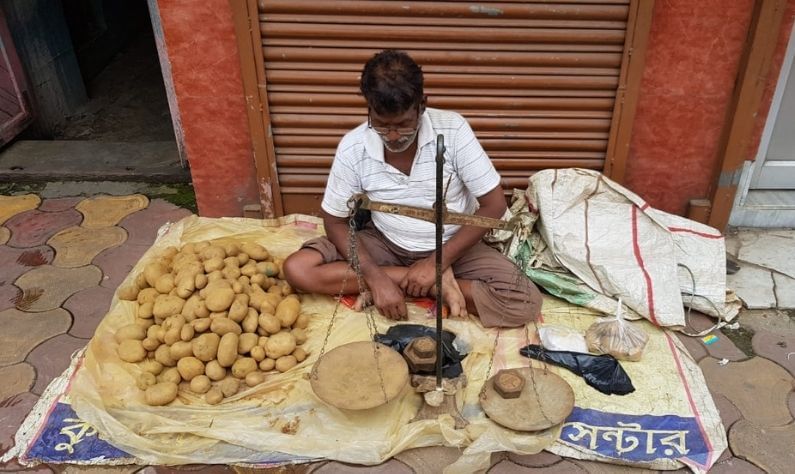 ফুটে আলু বেচছেন কুমারটুলির প্রতিমা শিল্পী