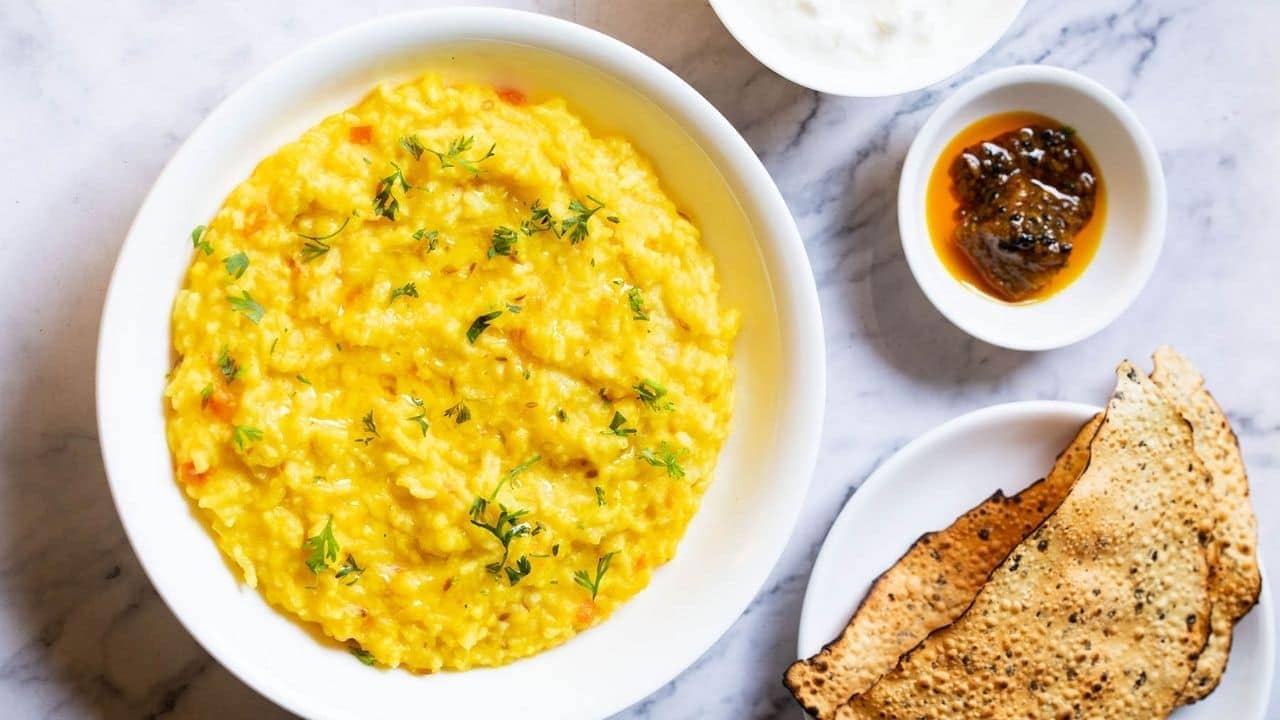 Khichdi Recipe: বাইরের অবিরাম বৃষ্টির সঙ্গে তাল রেখে লাঞ্চের মেনুতে আনুন অমোঘ পরিবেশ, বানিয়ে ফেলুন কারমাবাইয়ের খিচুড়ি...