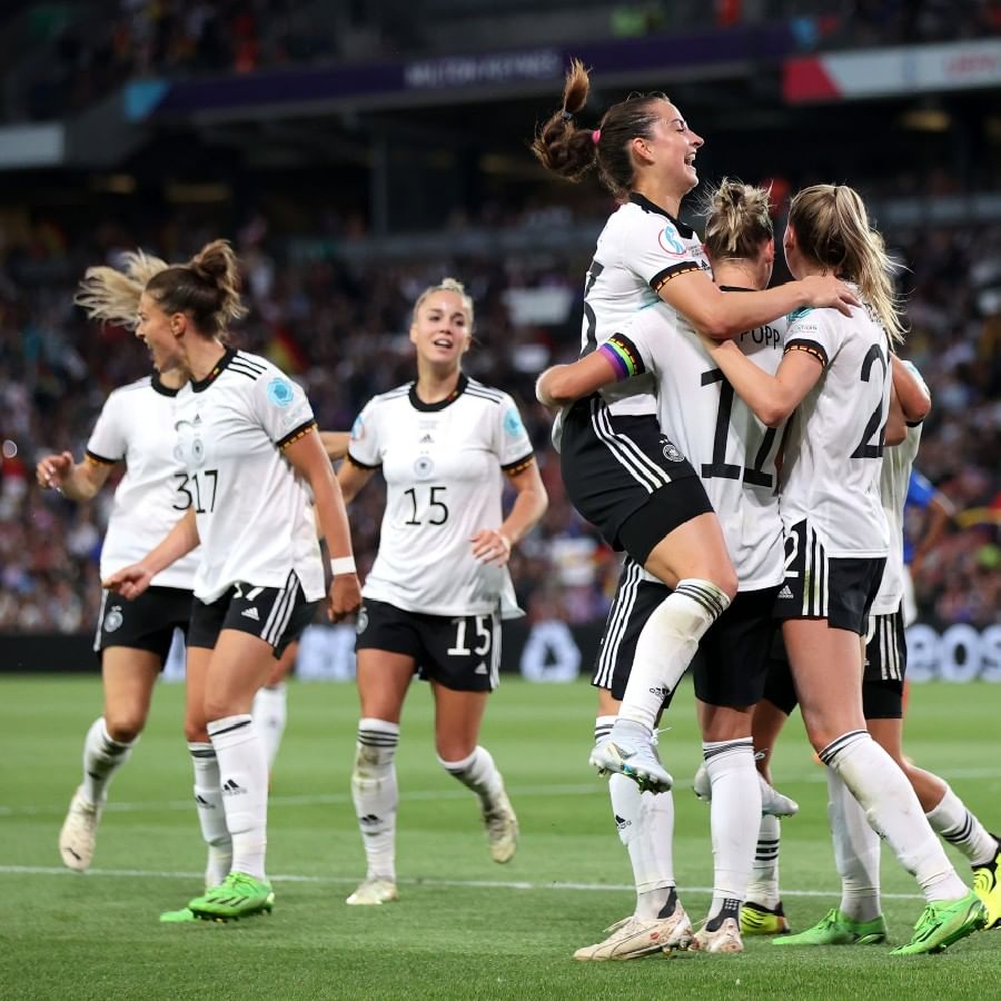 মেয়েদের ইউরো কাপের (UEFA Women's EURO Cup) সেমিফাইনালে ফ্রান্সকে (France) ২-১ ব্যবধানে হারাল জার্মানি (Germany)। অধিনায়ক আলেকজান্দ্রা পপের জোড়া গোলের সুবাদে নবম খেতাবের সামনে দাঁড়িয়ে জার্মানি। যদিও সেমিফাইনালে গোলদর্শন হয়নি ফ্রান্সের। মেরলে ফ্রোয়েমসের একখানা আত্মঘাতী গোলের কারণে ফ্রান্স একটা সময় সমতায় ফিরেছিল। কিন্তু জার্মানিকে শেষ অবধি উদ্ধার করে তাদের অধিনায়ক। এ বার ফাইনালে জার্মানির প্রতিপক্ষ ইংল্যান্ড। (ছবি-মেয়েদের ইউরো কাপ ২০২২ টুইটার)