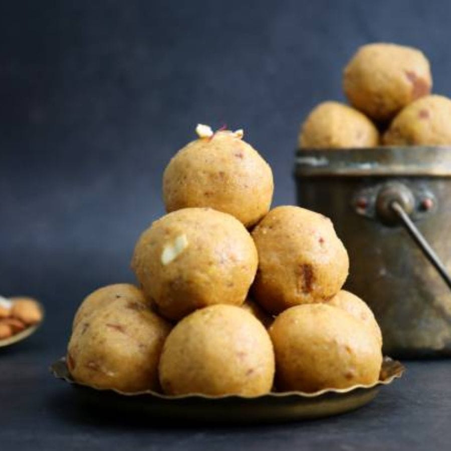 এবার এর মধ্যে চিনির রস মিশিয়ে ভাল করে পাক করে নিন। এবার এর মধ্যে বড় ৩ চামচ গাওয়া ঘি দিন। মিশ্রণ থেকে ঘি আলাদা হলে নামিয়ে নিন। সামান্য ঠাণ্ডা হলে হাতে ঘি মাখিয়ে নাড়ু পাক করে নিন। 