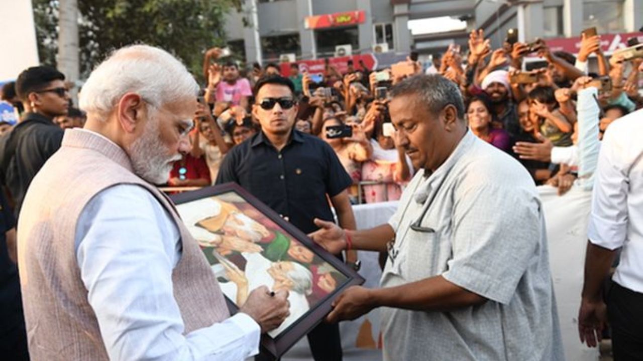 গুজরাটে এক ব্যক্তি প্রধানমন্ত্রী ও তাঁর মায়ের হাতে আঁকা ছবি তুলে দিচ্ছেন নরেন্দ্র মোদীর হাতে। ছবি- narendramodi.in