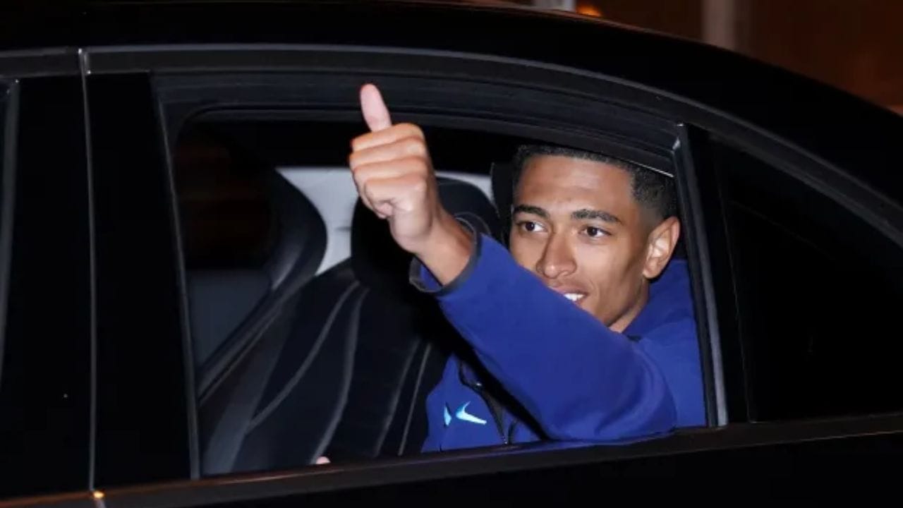 দলের মিডফিল্ডার জুড বেলিংহাম গাড়িতে বসেই 'থাম্বস আপ' দেখালেন। তাঁর ঠোঁটের কোনায় মৃদু হাসি জানান দিচ্ছিল, এ শুধুই সৌজন্যের হাসি। (ছবি:টুইটার)