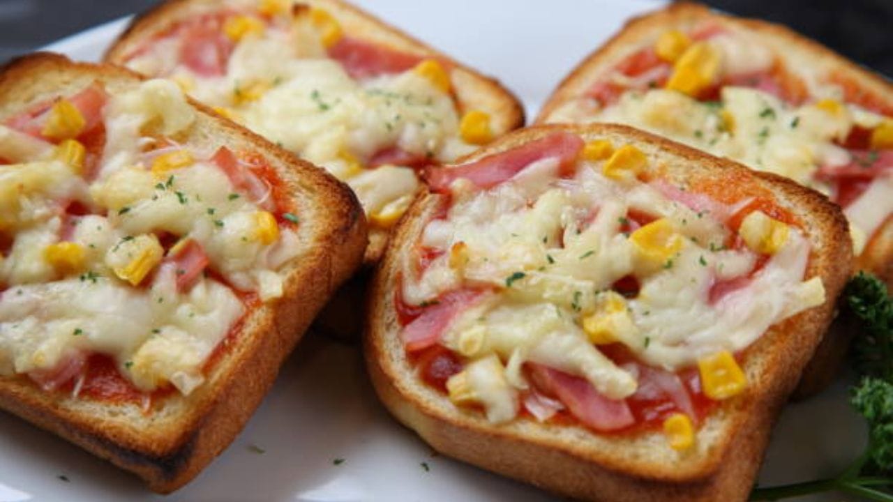 চারটে হোয়াইট বা ব্রাউন ব্রেড নিলেই চলবে। এবার একটা ছোট বাটি ক্যাপসিকাম, টমেটো, সেদ্ধ স্যুইটকর্ন, পেঁয়াজকুচি, অরিগ্যানো, মাখন, চিলিফ্লেক্স, মিক্স হার্বস, পিৎজা সস, চিলি ফ্লেক্স লাগবে এই পিৎজা বানাতে। একটা বড় বাটিতে সব সবজিগুলো মিশিয়ে নিন 