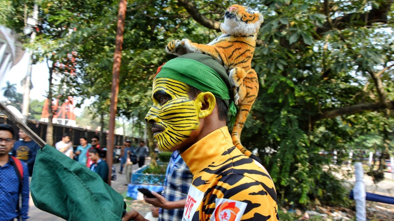 ইডেনের বাইরে ঢেলে বিক্রি হচ্ছে বাংলাদেশের জার্সি। সেখান থেকে জার্সি কিনে নিয়ে স্টেডিয়ামে ঢুকছেন দর্শকরা। বাবা-মায়ের হাত ধরে খেলা দেখতে এসেছে শিশুরাও। (ছবি:রাহুল সাধুখাঁ)