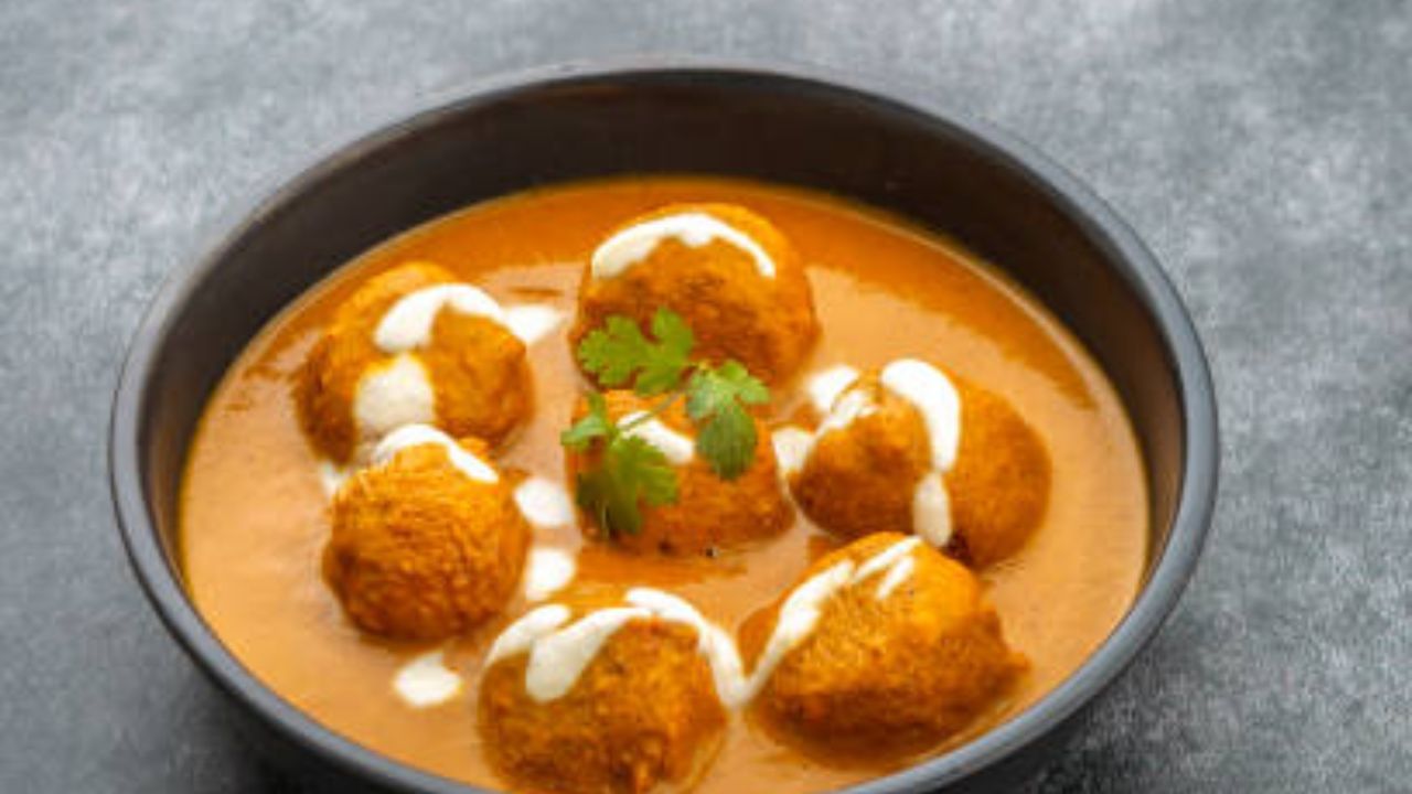 একটা টমেটো কুচি করে মিশিয়ে দিতে হবে। মাঝারি আঁচতে মশলা কষিয়ে স্বাদমতো নুন, জিরে-ধনে গুঁড়ো দিয়ে মশলা কষিয়ে নিতে হবে। স্বাদমতো চিনি দিয়ে একটু জল দিয়ে গ্রেভি বানিয়ে নিতে হবে। ঝোল ফুটে উঠলে কোফতা গুলো ছেড়ে দিন 