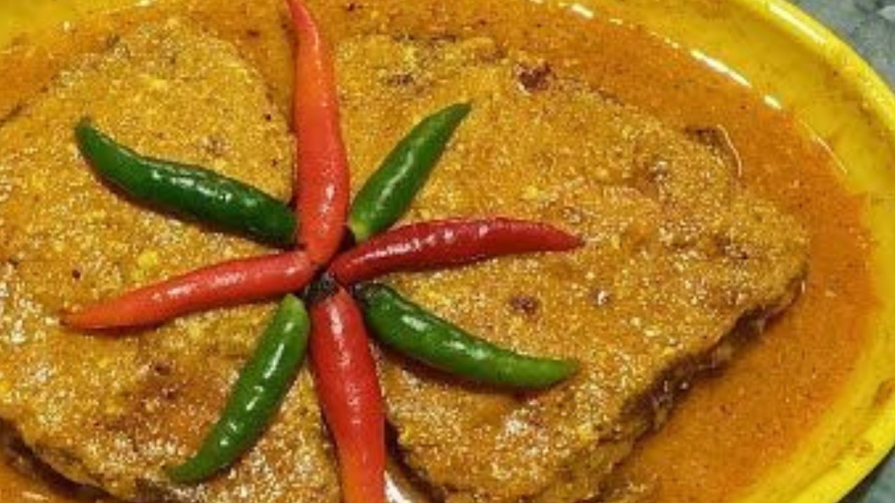 কয়েকটি কাঁচা লঙ্কা ফেলে দিন। এরপর ঢাকা দিয়ে ঝোল ফোটার সময় দিন। ঝোল ফুটে গেলে নামিয়ে নিন। গরম-গরম ভাতের সঙ্গে পরিবেশন করুন বাসন্তী কাতলা। (ছবি: Pinterest)