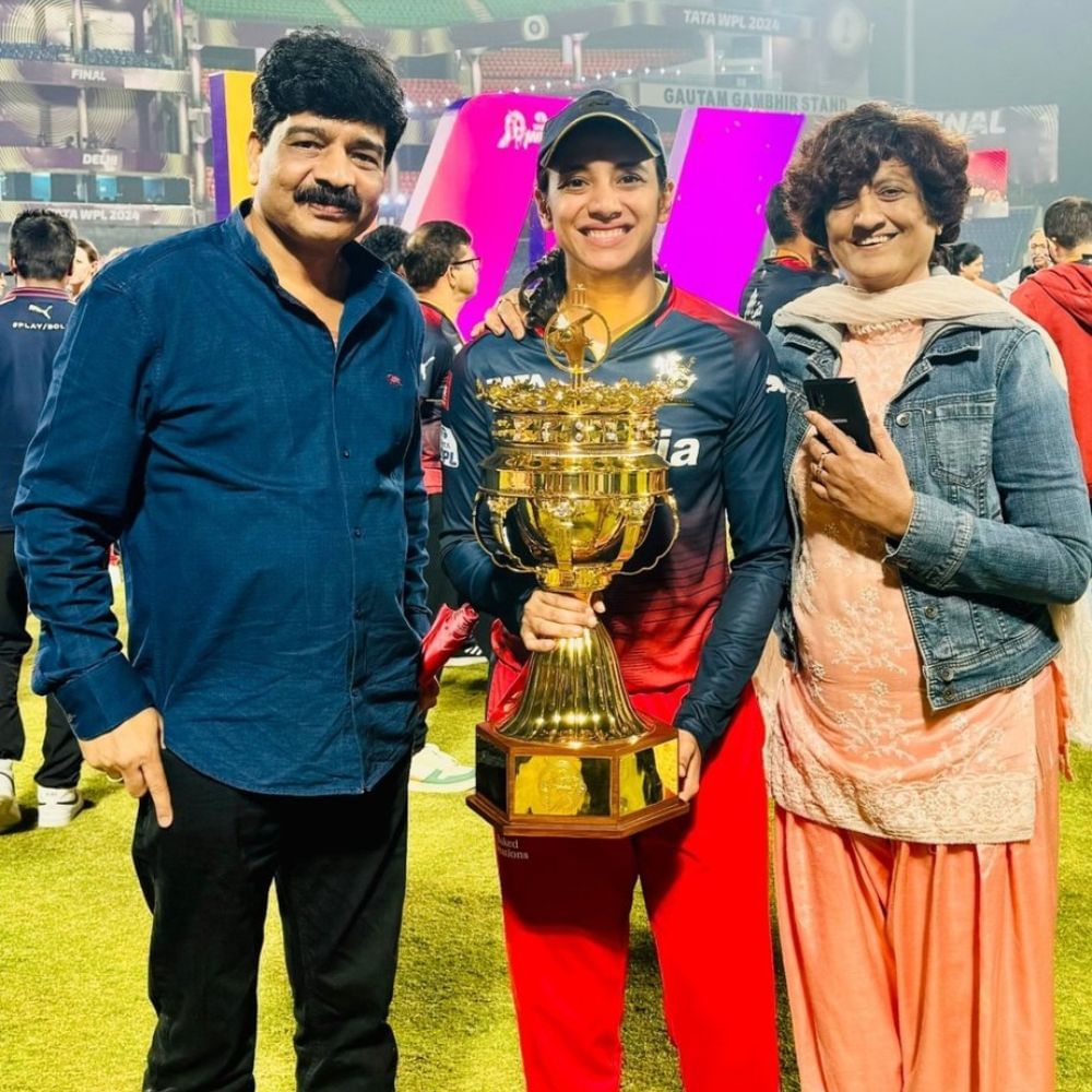 Smriti with Palash's mother and father with WPL trophy