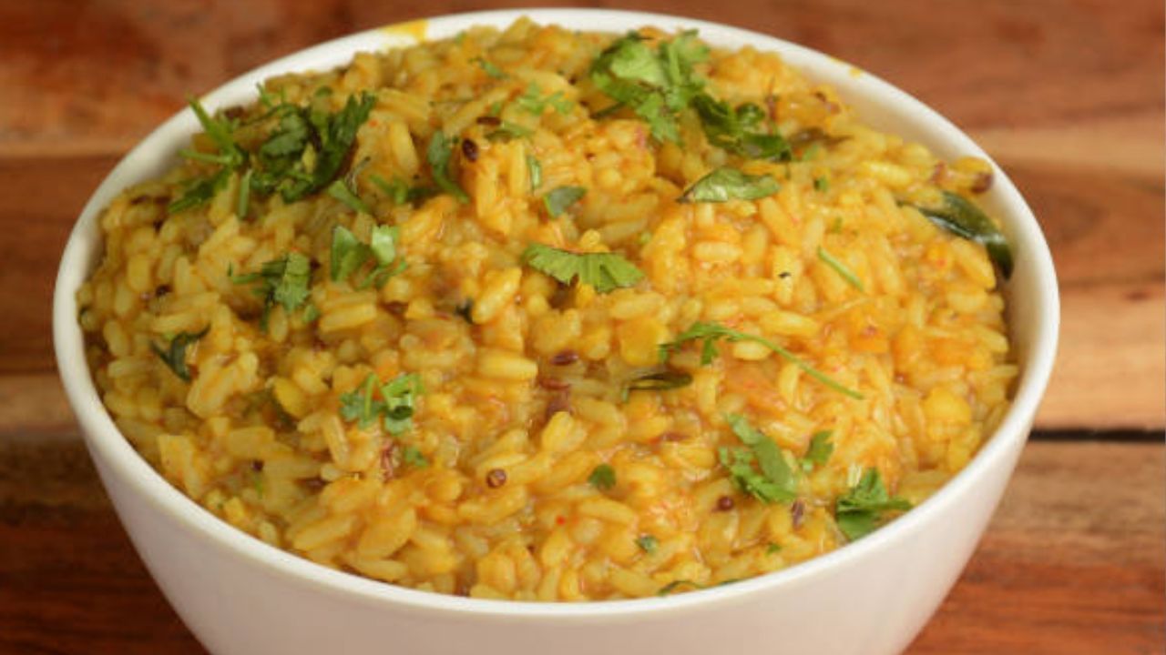 এবার ওই ভাজা মশলার মধ্যে জল ঝরানো চাল ও ডাল ঢেলে একটু ভেজে নিন। চাল ও ডাল মশলার সঙ্গে মিশে গেলে পর্যাপ্ত জল দিয়ে কড়াইয়ে ঢাকনা দিয়ে ফোটান। ১০-১৫ মিনিট ফোটার পর চাল, ডাল ভাল সেদ্ধ হয়ে গেলে গোটা কাঁচা লঙ্কা দিয়ে হালকা নেড়ে নামিয়ে নিন