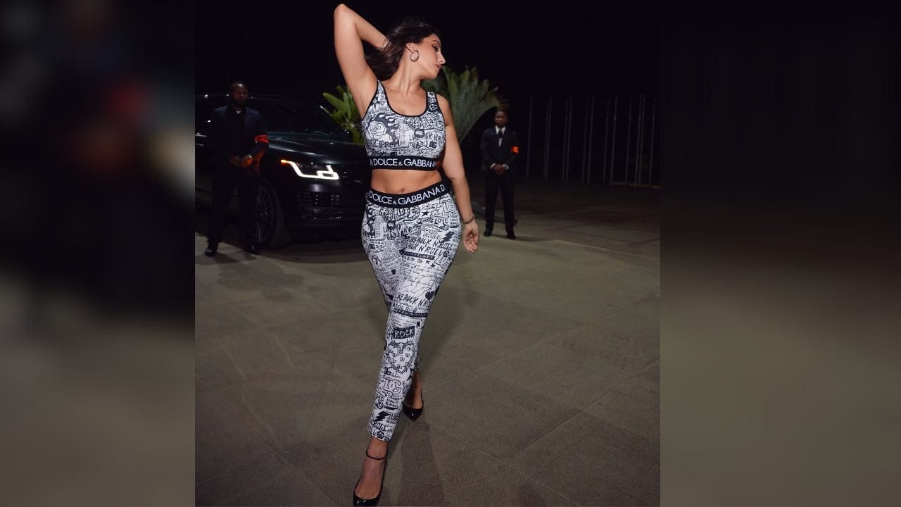 খবর পড়েন না, তৈরি করেন...। নোরা ফতেহির ক্ষেত্রে যেন এই কথাটা খাটে। দিল্লিতে একটি কনসার্টে এমন সারপ্রাইজ এন্ট্রি নিয়েই খবরে। ছবি: Instagram