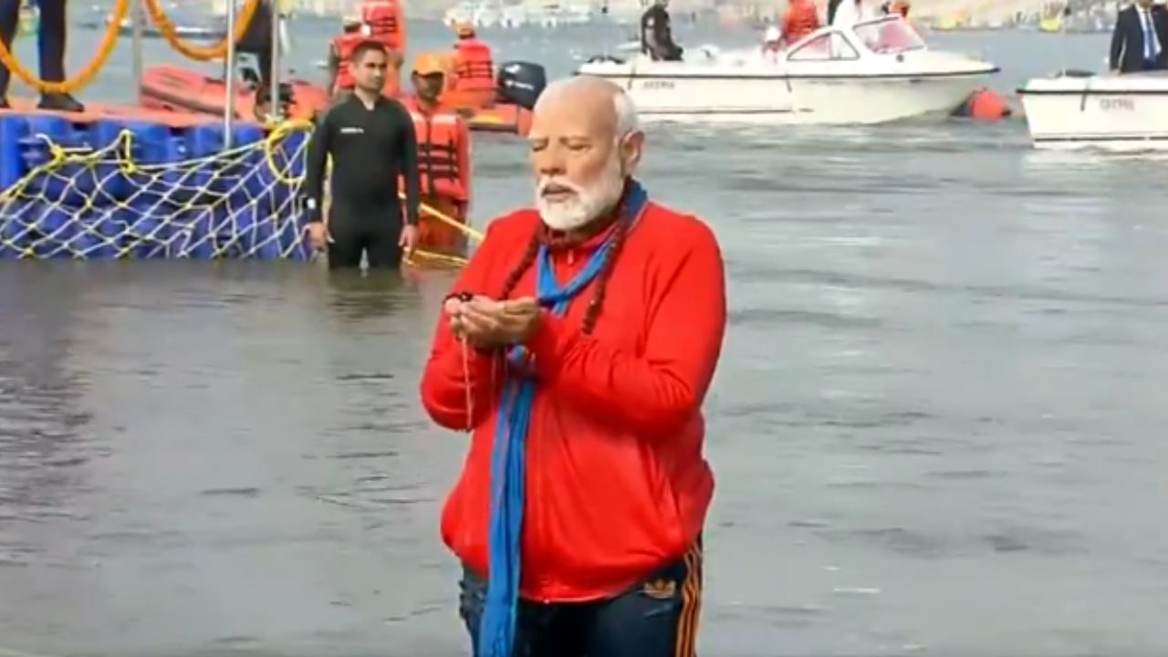 লাল জামা, কালো ট্রাক প্য়ান্ট ও নীল মাফলার গলায় মহাকুম্ভে পুণ্যস্নান করতে নামেন প্রধানমন্ত্রী। 