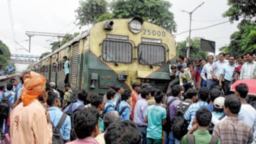 Train Disrupted: পর পর স্টেশনে দাঁড়িয়ে ট্রেন, অফিস টাইমে ট্রেন থামিয়ে লাইনে শুয়ে পড়লেন শিয়ালদহ শাখার নিত্য যাত্রীরা, কেন?