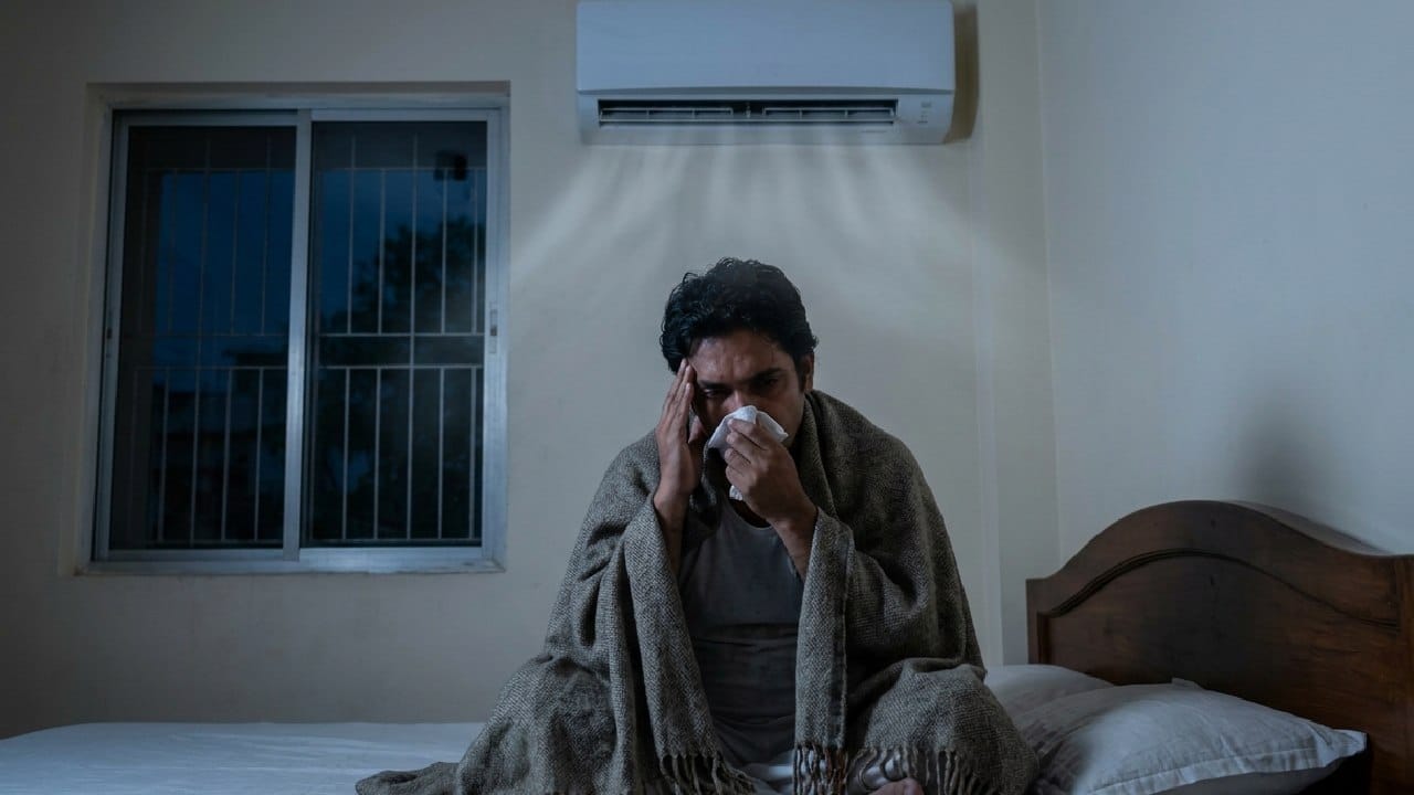 খাটের ঠিক ওপরে এসি থাকলে ঠান্ডা বাতাস সরাসরি আপনার মাথায়, বুকে বা মুখে এসে লাগে। এর ফলে মাঝরাস্তায় শরীরের তাপমাত্রা আকস্মিক কমে গিয়ে সাইনাস, তীব্র মাথাব্যথা, ক্রনিক সর্দি-কাশি এবং পেশিতে টানের মতো একাধিক দীর্ঘমেয়াদি স্বাস্থ্য সমস্যা দেখা দিতে পারে। চিকিৎসকদের মতে, সরাসরি এসির ঠান্ডা বাতাস শরীরের সংস্পর্শে আসা একদমই ভালো নয়। Gemini Ai