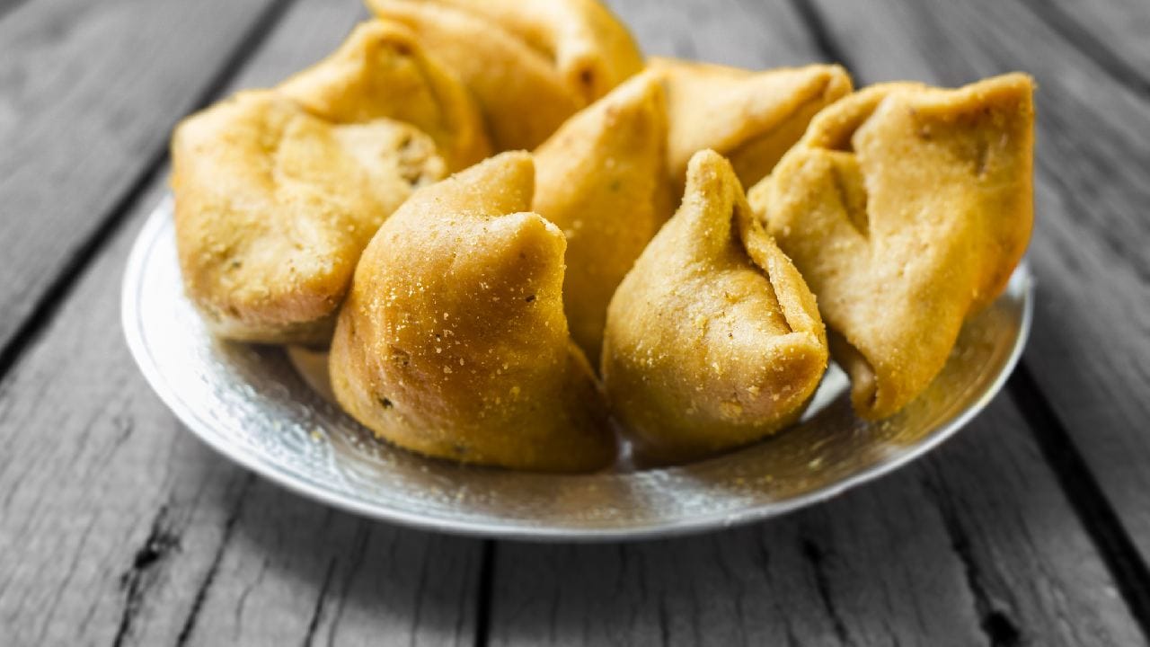 যদিও বিশ্বায়নের যুগে অক্সফোর্ড ডিকশনারি সরাসরি 'Samosa' শব্দটিকেই ইংরেজি অভিধানে পাকাপোক্ত জায়গা করে দিয়েছে। ফলে আন্তর্জাতিক যে কোনও মেনু কার্ডে এটি এখন আর ইংরেজি অনুবাদের মুখাপেক্ষী নয়। নিজের আসল নামেই বিশ্বজুড়ে দাপটের সঙ্গে পরিচিতি পেয়েছে এই খাস্তা খাবার। Getty Images